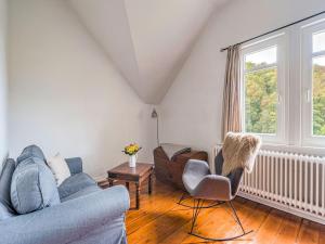 uma sala de estar com um sofá, uma cadeira e uma janela em Rustic Apartment with Garden in Bad Harzburg Germany em Bad Harzburg