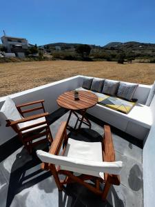 um pátio com uma mesa, cadeiras e um sofá em Casa Karavola in Galanado village-Naxos em Galanádhon