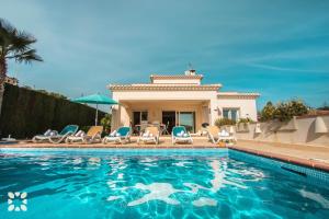een zwembad met stoelen en een huis bij Villa Baladrar Way by Abahana Villas in Benissa