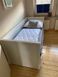 1 cama blanca pequeña en una habitación pequeña en Ferienhaus Stadthaus, en Wunstorf