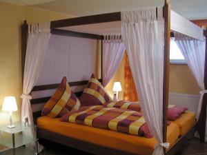 ein Schlafzimmer mit einem Himmelbett und zwei Kissen in der Unterkunft Wellness-Ferienwohnung Strandperle in Cuxhaven