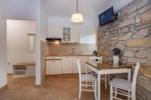 eine Küche mit einem Tisch und einer Steinmauer in der Unterkunft Villa Tupljak, luxury and comfort in a hidden summer hideout in Gromnik