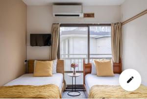 2 camas en una habitación con ventana en Momo palace, en Tokio