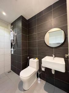 a bathroom with a toilet and a sink and a mirror at The Urban Left at Horizon Suites KLIA in Kampong Melot