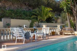 a patio with a table and chairs next to a pool at Villa Baladrar by Abahana Villas in Benissa