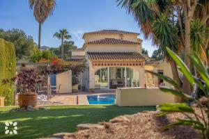 a villa with a swimming pool and palm trees at Villa Baladrar by Abahana Villas in Benissa