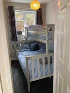 a bedroom with two bunk beds and a window at Sandy Beach Hill View Apartment Brean in Brean