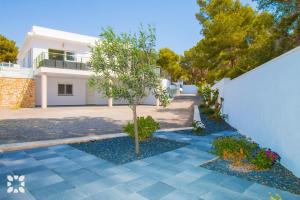 a house with a tree in front of a driveway at Villa Baydal by Abahana Villas in Benissa