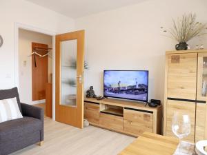 a living room with a television on a wooden entertainment center at Einfaches 2-Zimmer-Appartement mit Balkon. in Westerland