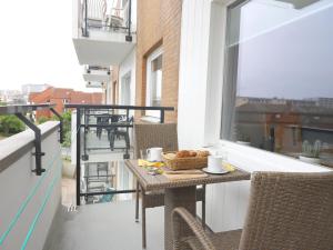 a balcony with a table with a basket of food on it at Einfaches 2-Zimmer-Appartement mit Balkon. in Westerland