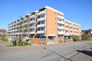 an apartment building on the side of a street at Einfaches 2-Zimmer-Appartement mit Balkon. in Westerland