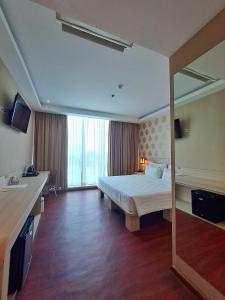 a hotel room with a bed and a large window at Ancyra by Continent - Poso in Poso