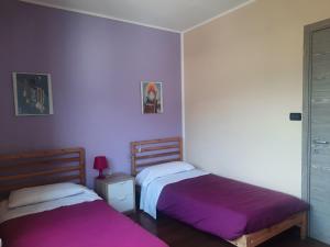 アオスタにあるAppartamento Elisaの紫の壁のドミトリールーム ベッド2台