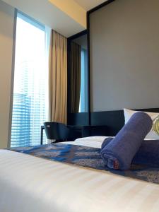 um quarto de hotel com uma cama com uma grande janela em Tropicana The Residences By RS em Kuala Lumpur