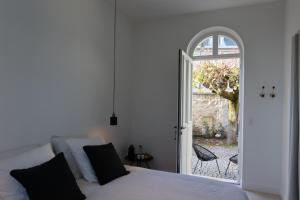 a bedroom with a bed and an open door to a patio at Lomalia in Parmain