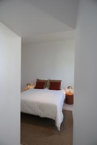a bedroom with a white bed and two lamps at Lomalia in Parmain