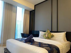 um quarto com uma cama grande e uma janela grande em Tropicana The Residences By RS em Kuala Lumpur