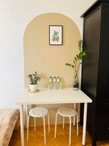 una mesa blanca con dos taburetes en una habitación en BESKID HOME, en Bielsko-Biala