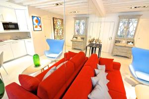 sala de estar con sofá rojo y sillas azules en Notre Dame In Full Colors en París