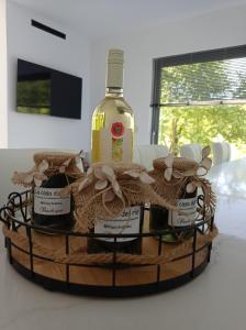 a bottle of wine on a basket on a table at La Casa Del Rio in Kymi