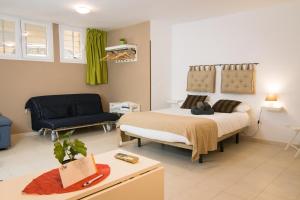 a bedroom with a king sized bed and a couch at Holidays2Malaga Studios Juan de Mena in Málaga