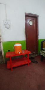 un banco rojo con una cesta naranja en una habitación en Chand Bibi Hotel en Peshawar