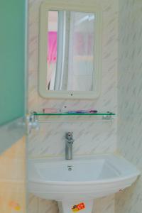 W łazience znajduje się umywalka z lustrem i lustrem. w obiekcie Raha house w mieście Nungwi
