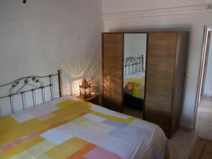 een slaapkamer met een bed, een ladekast en een spiegel bij Cortijo Pura Vida in Cómpeta