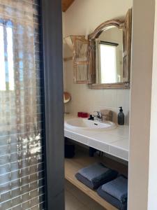 La salle de bains est pourvue d'un lavabo et d'un miroir. dans l'établissement Les tranquilles d'Oléron, à La Cotinière