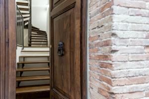 otwarte drzwi z ceglaną ścianą i schodami w obiekcie B&B Vico Suites w mieście Vico nel Lazio