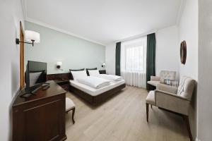メラーノにあるホテル イザベッラのベッドと椅子付きのホテルルーム
