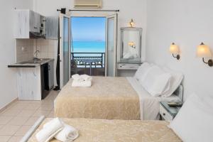 1 dormitorio con 2 camas y vistas al océano en ARTEMIS beach studios, en Kalamaki