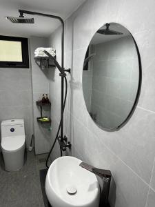 baño con espejo y aseo blanco en Happy House en Hanói