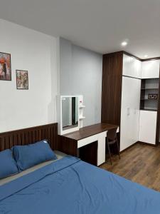 1 dormitorio con 1 cama y escritorio con TV en Happy House en Hanói
