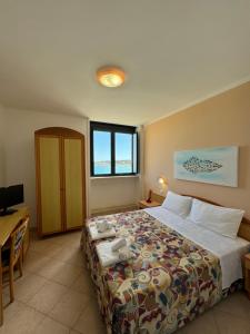 a hotel room with a bed and a desk at Villa Altomare in Otranto