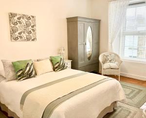 a bedroom with a large bed and a chair at The Old Post House B&B in St Just