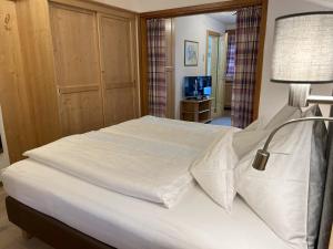 a bedroom with a large white bed with a lamp at Gästehaus "Ski-Depot" in Seefeld in Tirol