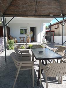 een patio met een tafel en stoelen onder een paviljoen bij Olympian Chalet in Paralia Katerinis