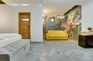 1 dormitorio con cama y sofá amarillo en Chillout House, en Sótony