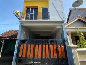 una casa con cancello e balcone di Duta Elite Kostel Syariah near RSUD Caruban Mitra RedDoorz a Madiun
