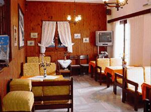 a living room with couches and a table and a tv at Villa Zacharo in Skala