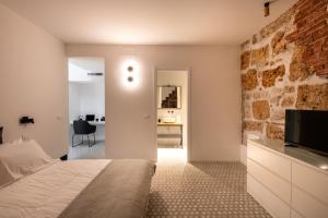 a bedroom with a bed and a brick wall at Casa Design tra le Mura by Wonderful Italy in Palermo