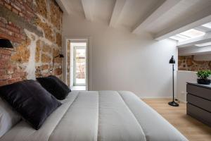a large white bed in a room with a brick wall at Casa Design tra le Mura by Wonderful Italy in Palermo