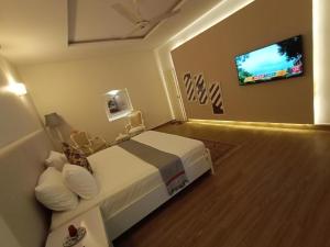 a hotel room with a bed and a flat screen tv at Heavenly Stays in Karachi