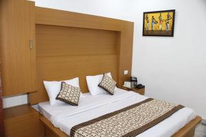 a bedroom with a bed with a wooden headboard at Trimrooms @ Katra Railway Station in Katra