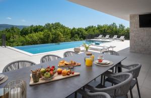 New Villa Hillside Gem heated pool,HotTub,Billiard : طاولة عليها طعام في فناء مع مسبح