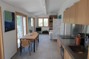 una cucina e una sala da pranzo con tavolo e sedie di Sète - Maison entière et jardin sur le Mont Saint Clair - vue mer et étang a Sète Altre 11 foto