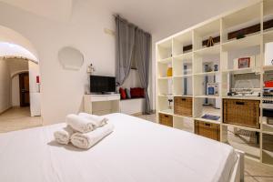 ein weißes Schlafzimmer mit Handtüchern auf dem Bett in der Unterkunft Via Nilo 30 in Neapel