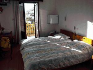 a bedroom with a large bed with a window at Villa Zacharo in Skala