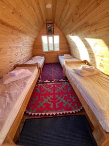 a room with three beds in a wooden cabin at Bosogo Yurt camp in Bokonbayevo